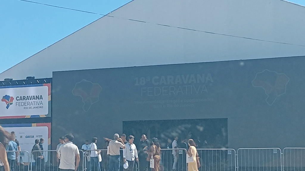 Fachada do evento 18ª Caravana Federativa no Rio de Janeiro, com pessoas na entrada e banners visíveis.