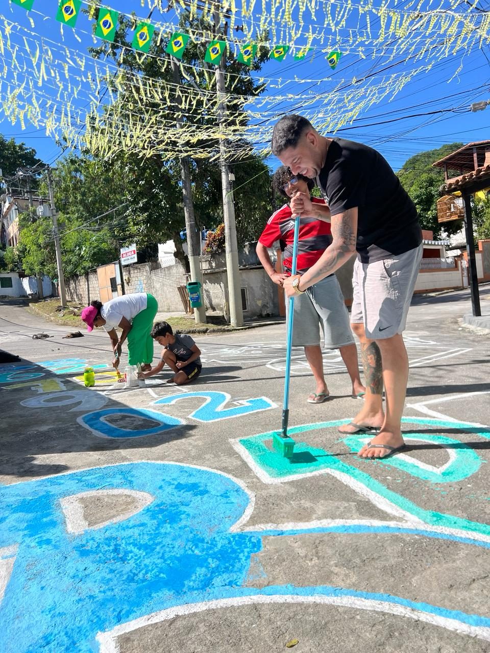 Projeto 'Copa da Cidade' resgata tradição e moradores pintam rua de verde e amarelo no bairro Santa Catarina